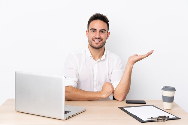 Jonge zakenman met een mobiele telefoon op een werkplek met copyspace denkbeeldig op de palm