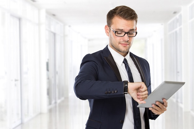 Jonge zakenman met een tablet op zijn hand