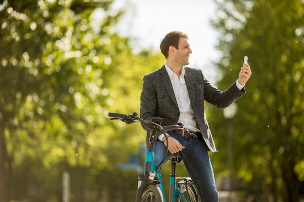 Jonge zakenman op de ebike die mobiele telefoon met behulp van om selfie foto te maken