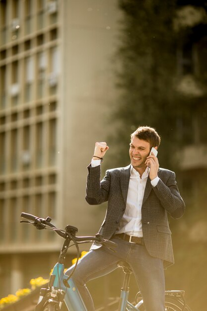 Jonge zakenman op de ebike met behulp van mobiele telefoon