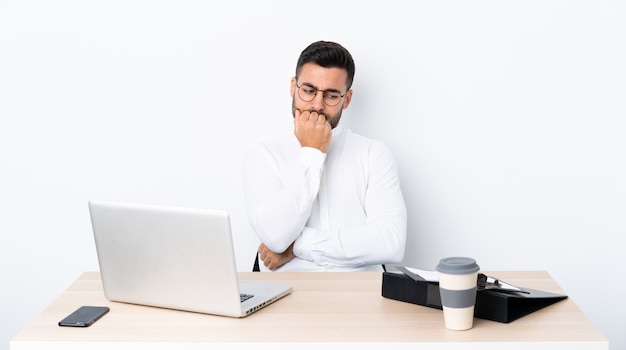 Jonge zakenman op een werkplek met twijfels