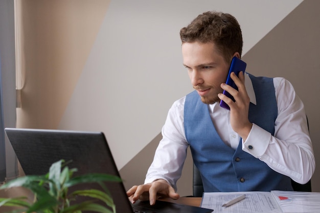 Jonge zakenman praten aan de telefoon en stress controleren van e-mail op laptop think