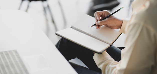 Jonge zakenman werkt aan zijn project tijdens het schrijven op laptop