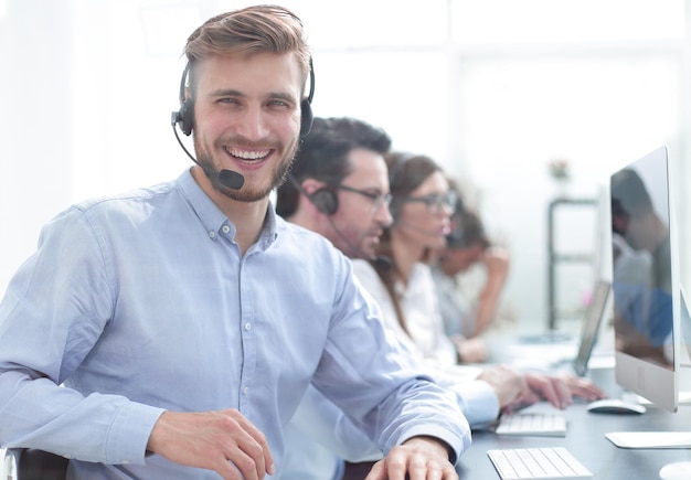 Jonge zakenman zittend aan de tafel in het callcenter