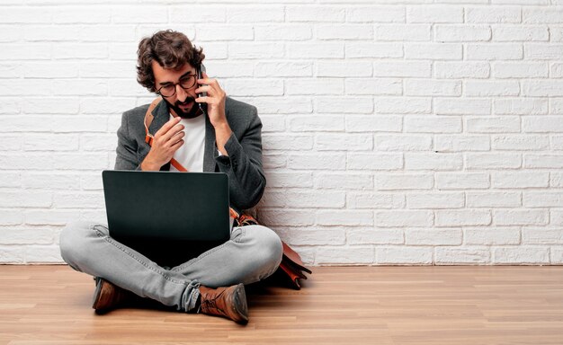 jonge zakenman zittend op de vloer met een laptop