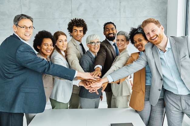 Jonge zakenmensen ontmoeten kantoor portret diversiteit teamwerk groep verbinding succes hand in hand eenheid senior volwassen collega samen