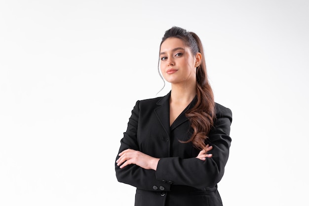 Jonge zakenvrouw armen gekruist in zwarte jas staande studio geïsoleerd op een witte achtergrond
