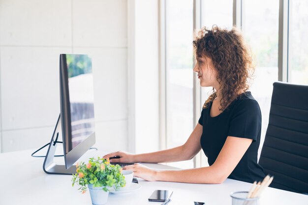 Foto jonge zakenvrouw die aan het bureau werkt