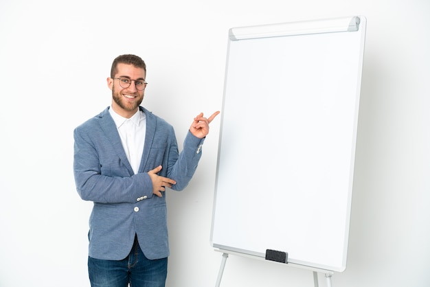 Jonge zakenvrouw die een presentatie geeft op wit bord geïsoleerd op een witte achtergrond wijzende vinger naar de zijkant