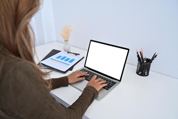 Jonge zakenvrouw die met computerlaptop aan haar bureau werkt