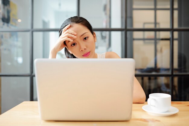 Jonge zakenvrouw die op laptop werkt