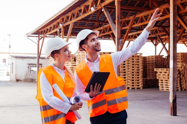 Jonge zakenvrouw en mannelijke ingenieur die van plan zijn de productie uit te breiden