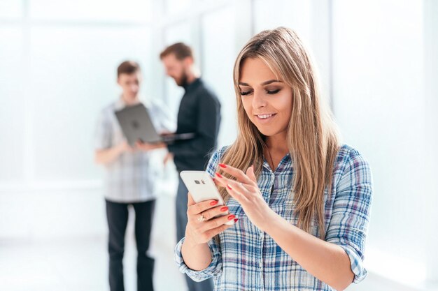 Jonge zakenvrouw kijken naar het scherm van haar smartphone