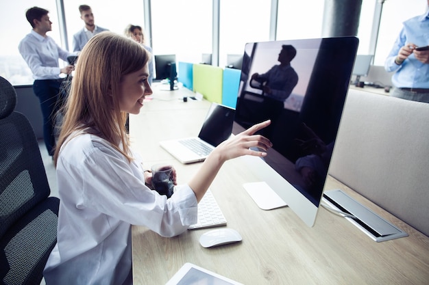 Jonge zakenvrouw met computer op kantoor.