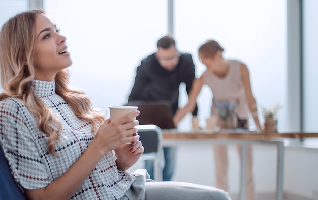 jonge zakenvrouw met een kopje koffie in een modern kantoor kantoor weekdagen