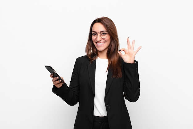 Jonge zakenvrouw met een telefoon met goedkeuring gebaar