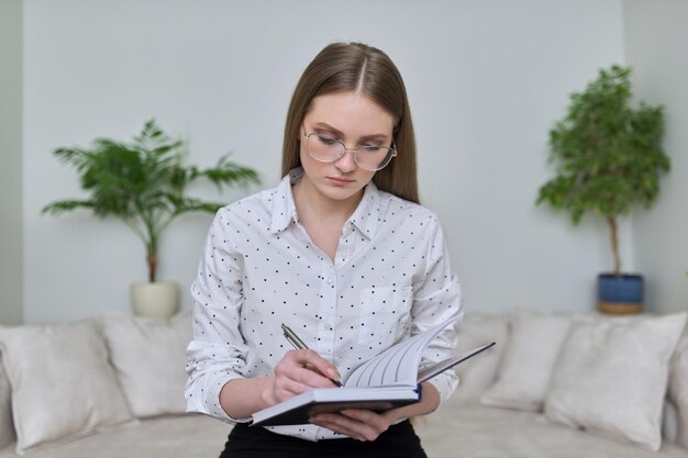 Jonge zakenvrouw met zakelijke notebook kijken naar webcam