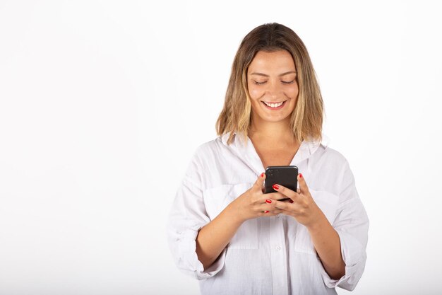 Jonge zakenvrouw portret met smartphone in studio