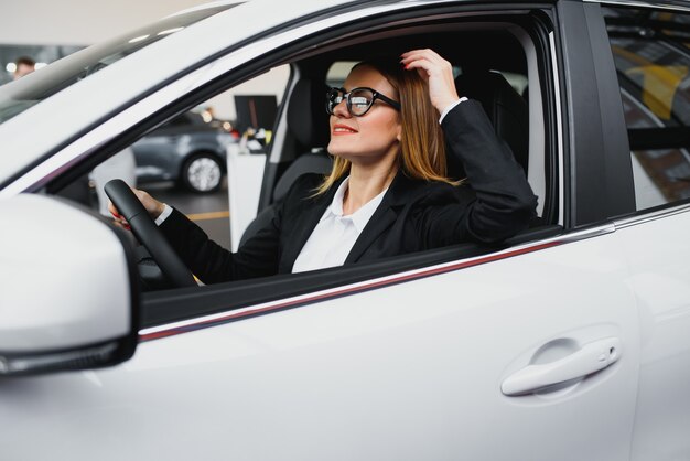 Jonge zakenvrouw rijden in haar auto om te werken.