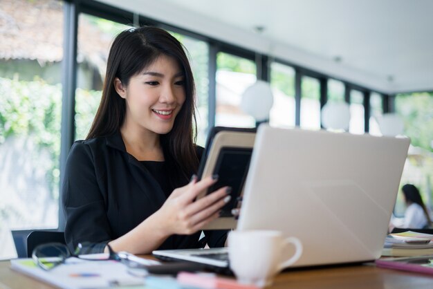 jonge zakenvrouw werken met mobiele laptop en documentsin office