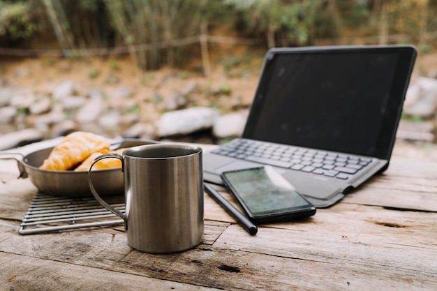 Foto jonge zakenvrouw werken op de computer in café op de rots jong meisje downshifter werken op een laptop bij zonsondergang of zonsopgang op de top van de berg naar de zee werkdag