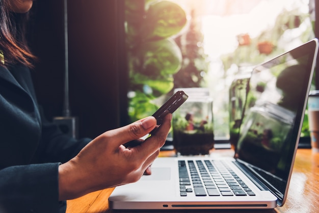 Jonge zakenvrouw werkt aan mobiele smartphone.