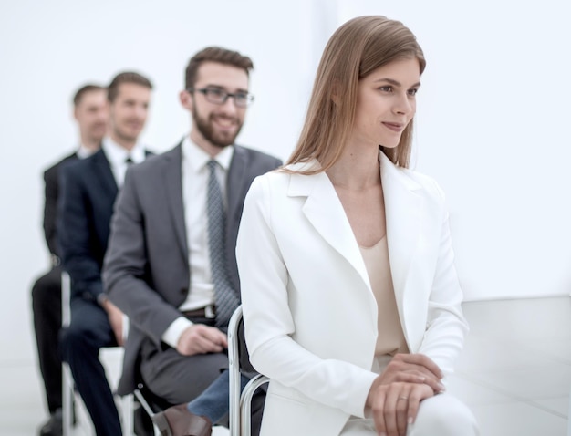 Jonge zakenvrouw zit op conferentiefoto met kopieerruimte