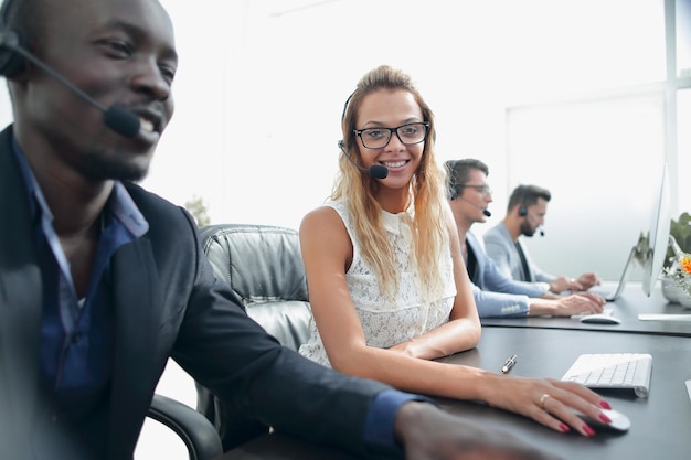 Jonge zakenvrouw zittend aan tafel in callcenter foto met kopieerruimte