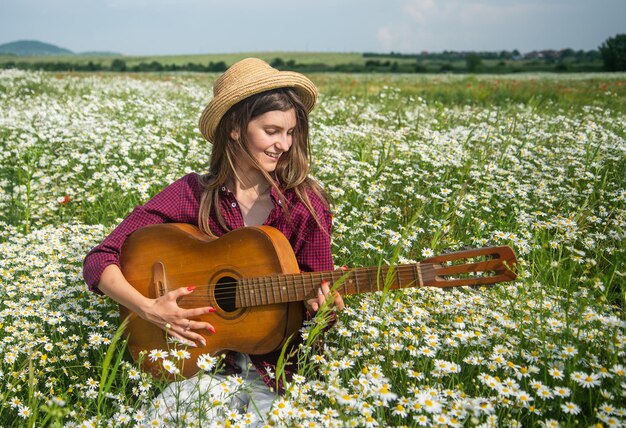 Jonge zangeres in papaverveld met gitaarmuziekgitarist