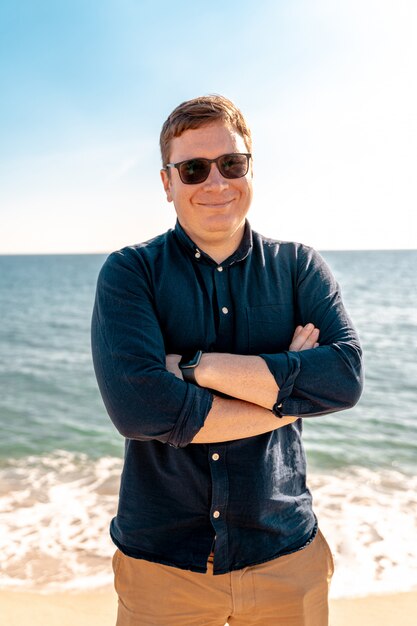 Jonge zelfverzekerde man op het oceaanstrand. Gelukkig freelancer. Zomervakantie Spanje, Barcelona