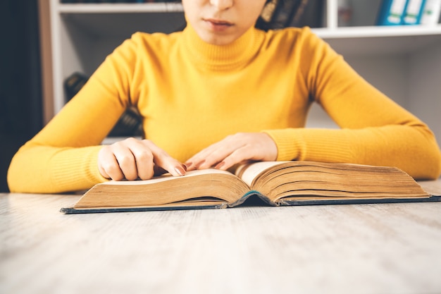 Jonge zittende vrouw leesboek