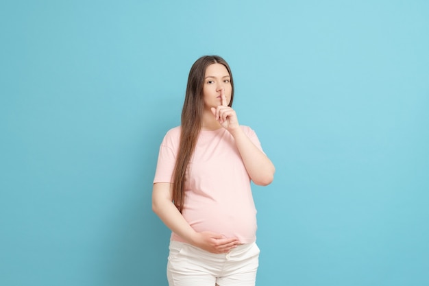 Jonge zwangere vrouw die stil geluid doet