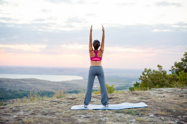 Jonge zwangere vrouw doet yoga buitenshuis