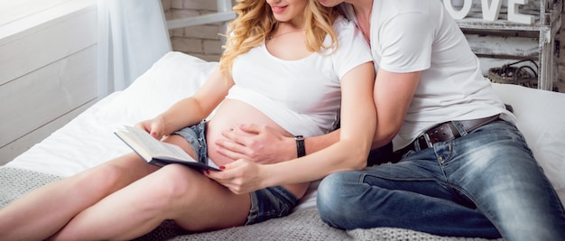 Foto jonge zwangere vrouw en haar echtgenoot die op baby wachten