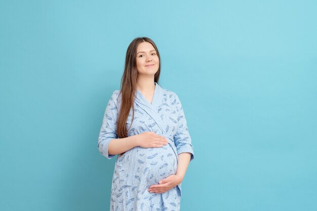 Jonge zwangere vrouw in badjas