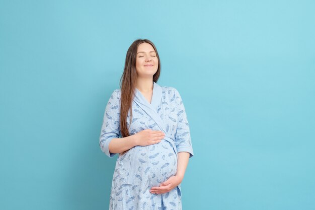 Jonge zwangere vrouw in een badjas