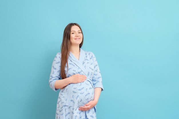 Jonge zwangere vrouw in een blauwe badjas