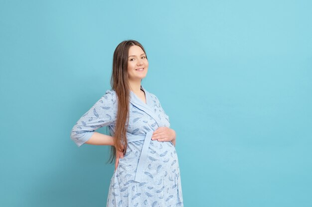 Jonge zwangere vrouw in een blauwe badjas