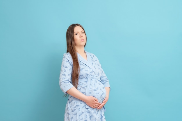 Jonge zwangere vrouw in een blauwe badjas