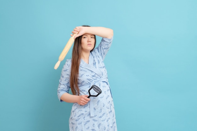 Jonge zwangere vrouw in een blauwe badjas