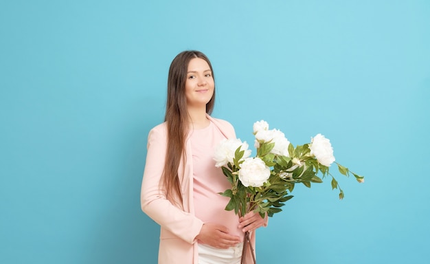 Jonge zwangere vrouw in een roze t-shirt met bloemen