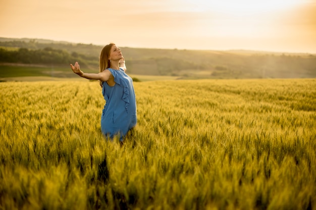 Jonge zwangere vrouw in het veld