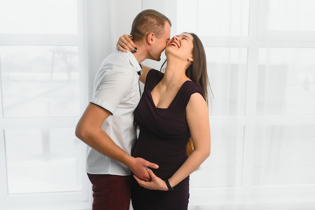 Jonge zwangere vrouw met echtgenoot poseren