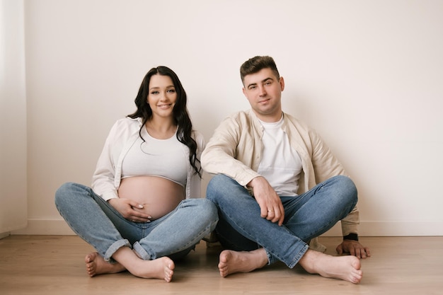 Foto jonge zwangere vrouw met echtgenoot thuis gelukkig gezin en zwangerschapsconcept