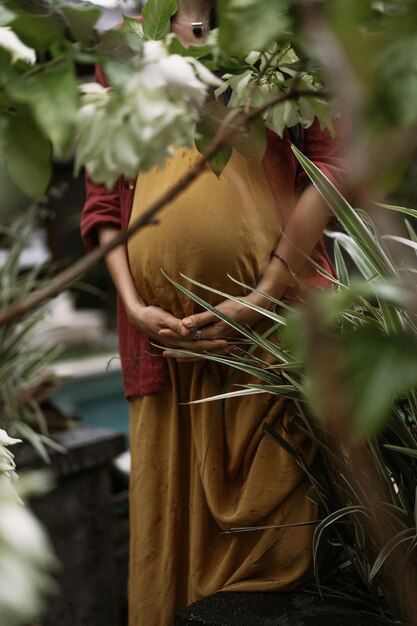 Foto jonge zwangere vrouw met lang donker haar op een tropische locatie