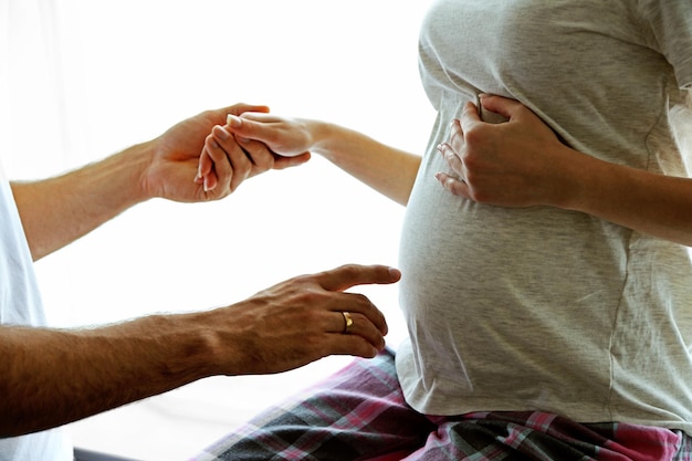 Foto jonge zwangere vrouw met man in de kamer.