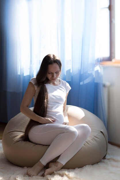 Jonge zwangere vrouw tussen de 30 en 35 jaar observeert haar buik