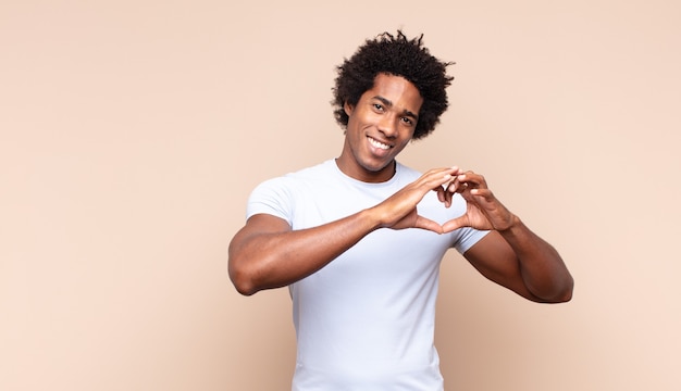 Jonge zwarte afro man die zich moe, gestrest, angstig, gefrustreerd en depressief voelt, rug- of nekpijn heeft