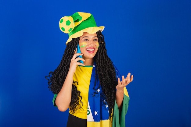 Jonge zwarte Braziliaanse voetbalfan die spreekt via spraakoproep spraakoproep via smartphone