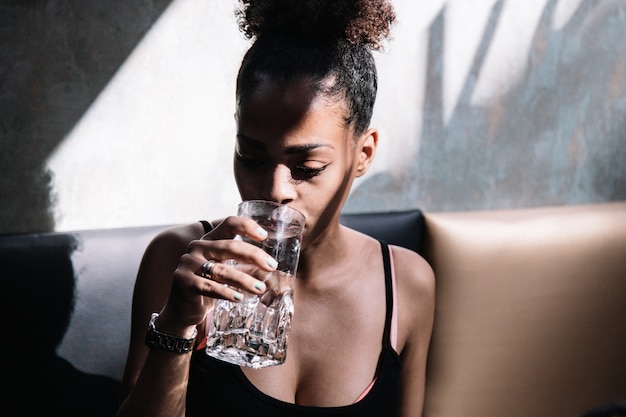 Foto jonge zwarte drinkwaterzitting op een bank